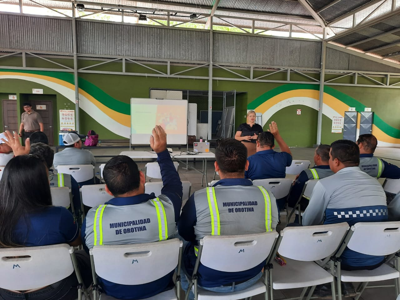 Taller de salud mental municipal con participantes levantando la mano